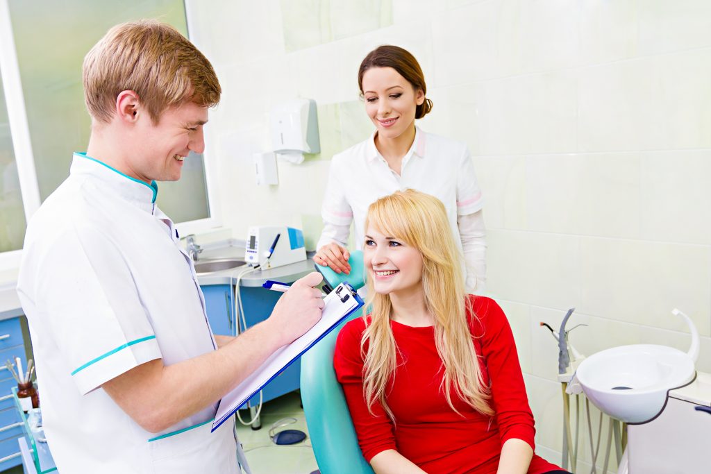 Female patient in dentist office, answering doctor questions